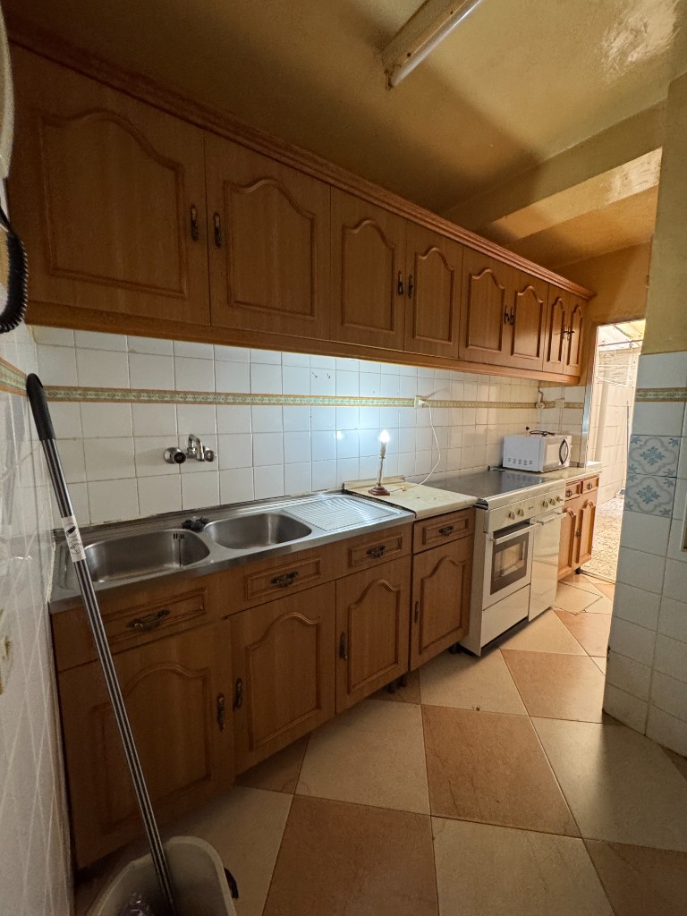 Cocina antigua con mobiliario de madera antes de la reforma en Madrid